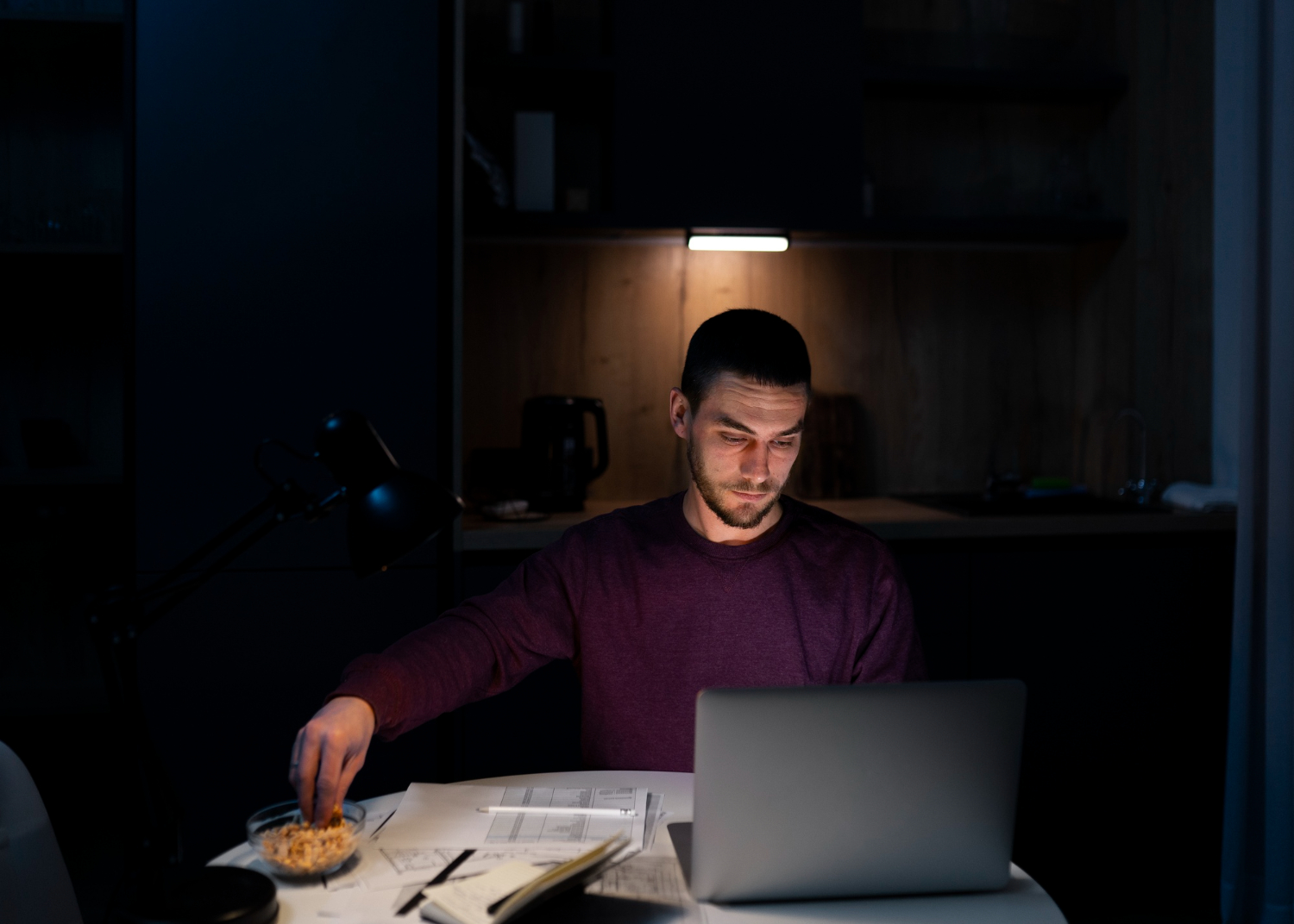 Homem de tiro médio trabalhando tarde da noite no notebook